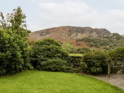 a field of grass with a mountain in the background at Thwaite How in Keswick
