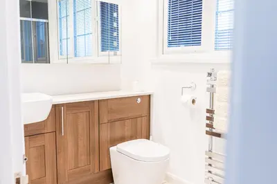 a bathroom with a toilet and a sink and windows at Town centre property convenient for the fells in Keswick