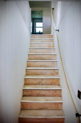 a staircase with wooden steps in a building at Bridgend Cottage, Auchencairn, Castle Douglas in Auchencairn