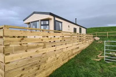 a fence around a tiny house in a field at Tarn Bay Retreat- Sea- Fells- Beach- Views-Farm in Millom