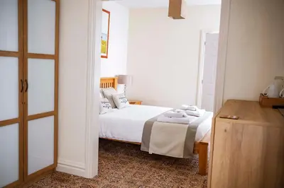 a bedroom with a bed with white sheets and pillows at OPUL EXPRESS - Inglewood in Douglas