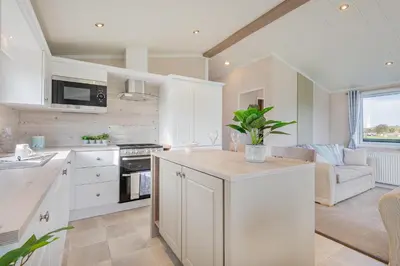 a kitchen with white cabinets and a counter top at Birch Timber Holiday Lodge in Bassenthwaite