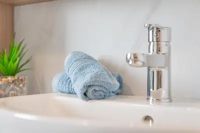 a towel sitting on a bathroom sink next to a faucet at Birch Timber Holiday Lodge in Bassenthwaite