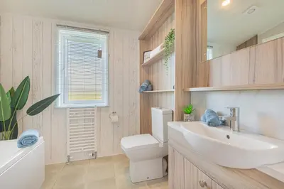 a bathroom with a white sink and a toilet at Birch Timber Holiday Lodge in Bassenthwaite
