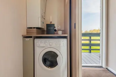 a washer and dryer in a room with a balcony at Birch Timber Holiday Lodge in Bassenthwaite