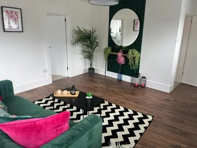 a living room with a green couch and a table at The Boyd - Coorie Doon in Prestwick