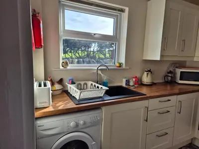 a kitchen with a sink and a washing machine at RAWSON COTTAGE LOVELY 2 BEDROOM SEMI RURAL in Stranraer