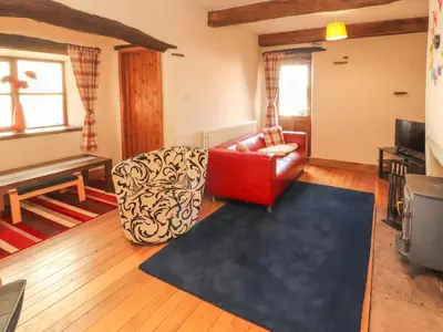 a living room with a red chair and a couch at Beck Edge in Keswick