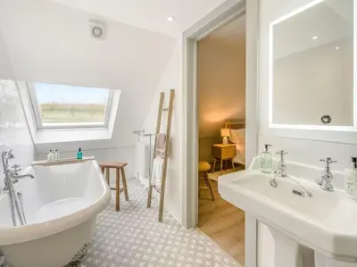 a bathroom with a tub and two sinks and a window at Blackside Cottage - A Luxury Rural Retreat in Mauchline
