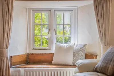 a living room with a couch and a window at farmhouse braithwaite mews in Keswick