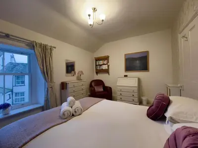 a bedroom with a bed with two towels on it at Spa Cottage in Braithwaite