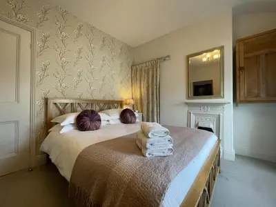 a bedroom with two beds and a mirror on the wall at Spa Cottage in Braithwaite