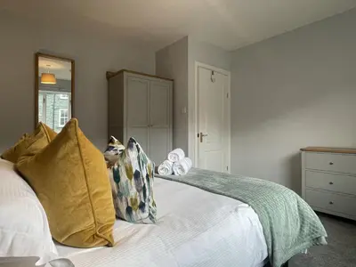 a bedroom with a white bed with yellow pillows at Red Robin in Keswick