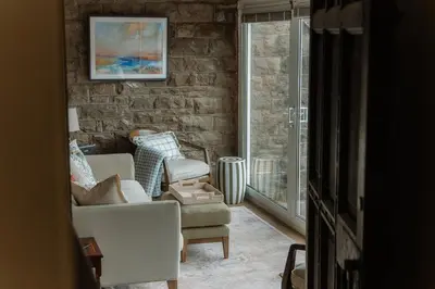 a living room with a couch and a chair and a window at Grey Walls in Penrith