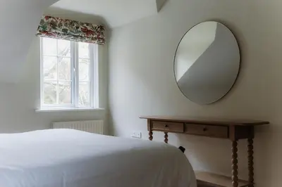 a bedroom with a bed and a mirror on the wall at Grey Walls in Penrith