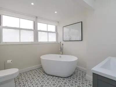 a white bathroom with a tub and a toilet at Forty Five in Keswick