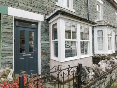 a stone house with a blue door and windows at Forty Five in Keswick