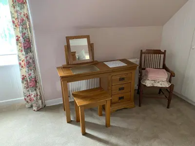 a desk with a mirror and a chair in a room at Glenterry Farmhouse in Kirkcudbright