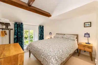 a bedroom with a bed and a window at Bridge Cottage Keswick in Keswick