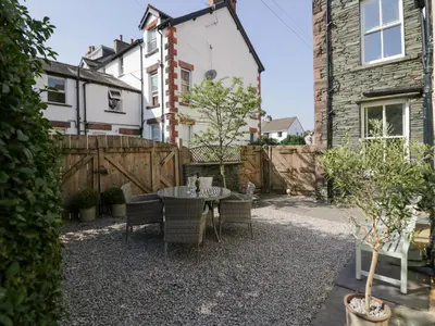 a backyard with a table and chairs and a fence at Heatherlea in Keswick