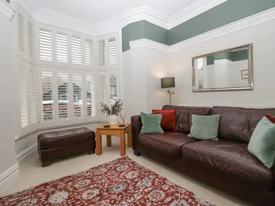 a living room with a brown leather couch and a table at Heatherlea in Keswick
