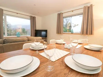 a dining room with a table with plates and glasses at Tandarra in Keswick