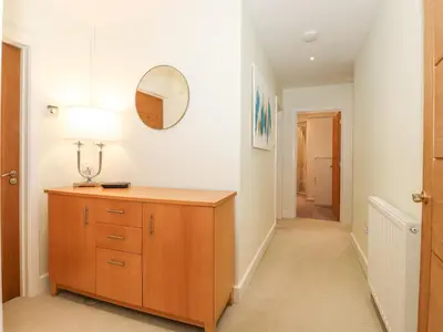 a hallway with a wooden dresser and a mirror at Tandarra in Keswick