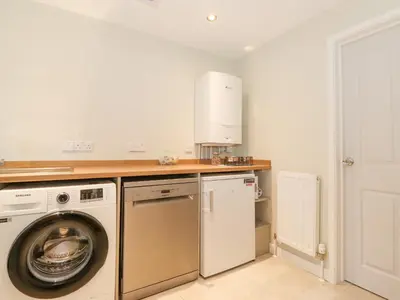 a kitchen with a washing machine and a washer at Tandarra in Keswick