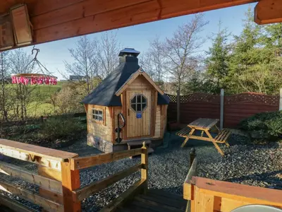 a small wooden house with a black roof at Ballinorig Lodge in Cleator Moor