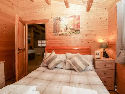 a bedroom with a bed in a log cabin at Ballinorig Lodge in Cleator Moor