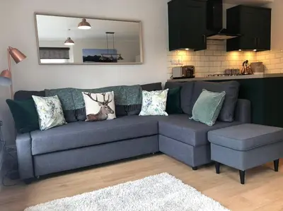 a living room with a blue couch and a kitchen at Fell Top View - Fantastic Keswick Centre apartment in Keswick