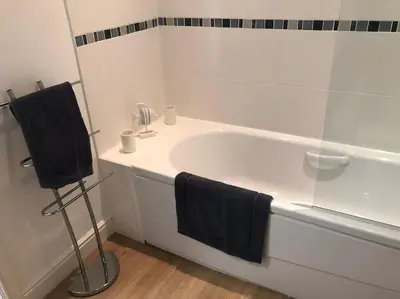 a bathroom with a white tub and a glass shower at Fell Top View - Fantastic Keswick Centre apartment in Keswick