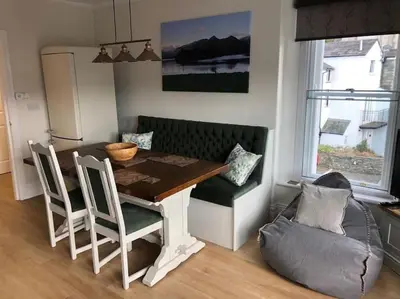 a dining room with a table and chairs and a couch at Fell Top View - Fantastic Keswick Centre apartment in Keswick