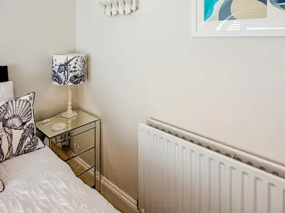 a bedroom with a bed and a lamp on a night stand at The Police Station - Uk45642 in Silloth