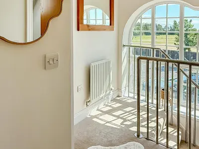 a hallway with a stairway with a mirror at The Police Station - Uk45642 in Silloth