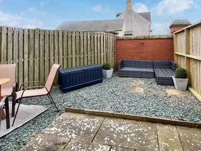 a backyard with a bench and a fence at The Police Station - Uk45642 in Silloth