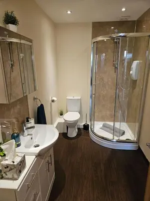 a bathroom with a shower and a toilet and a sink at Carlisle City Centre. Spacious Apartment. Ideal location. in Carlisle