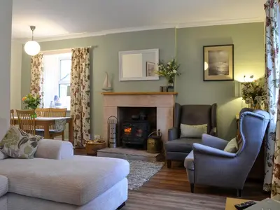 a living room with a couch and a fireplace at Clachries Cottage in Boreland of Colvend