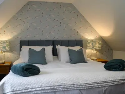 a bedroom with a bed with two pillows on it at Clachries Cottage in Boreland of Colvend