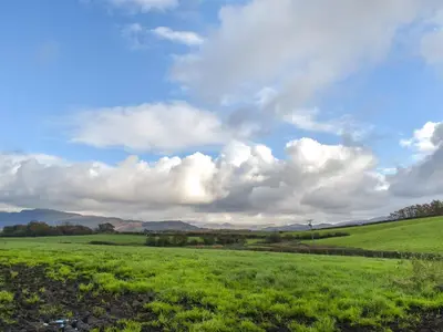 a field of green grass with a cloudy sky at Harebeck Cottage in Gosforth