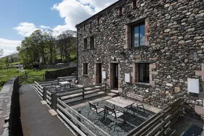 a group of benches sitting outside of a stone building at 2 Bed in Threlkeld SZ134 in Threlkeld