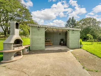 a green shed with a pizza oven in front of it at 1 Bed in Easton 56742 in Kirklinton