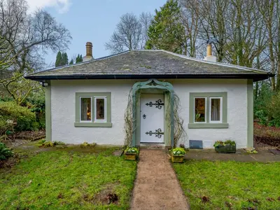 a small white house with an arch over the door at 2 Bed in Cockermouth 86528 in Arlecdon