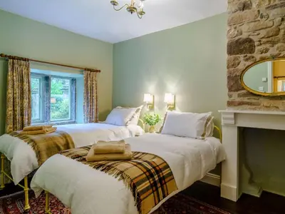 two beds in a room with a fireplace at 2 Bed in Cockermouth 86528 in Arlecdon