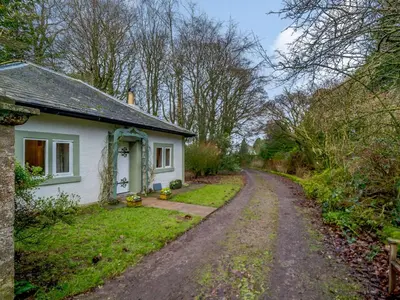 a small white house on a dirt road at 2 Bed in Cockermouth 86528 in Arlecdon