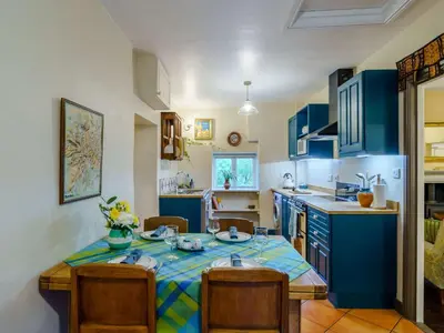a kitchen with blue cabinets and a table and chairs at 2 Bed in Cockermouth 86528 in Arlecdon