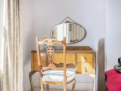 a wooden chair in front of a desk with a mirror at 2 bed in Keswick 87732 in Keswick