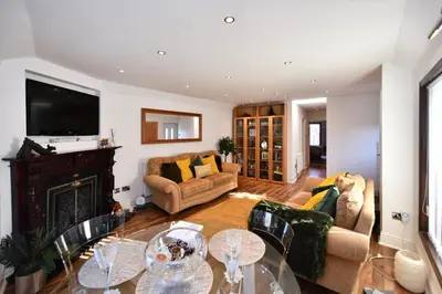 a living room with a table and a fireplace at The Lemon Tree in Prestwick