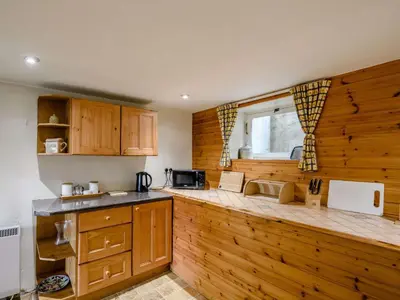 a kitchen with wooden cabinets and a counter top at 1 Bed in Eskdale SZ503 in Beckfoot