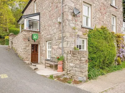 a stone building with a bench in front of it at 1 Bed in Eskdale SZ503 in Beckfoot